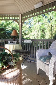 wicker chair on large wooden porch with railing