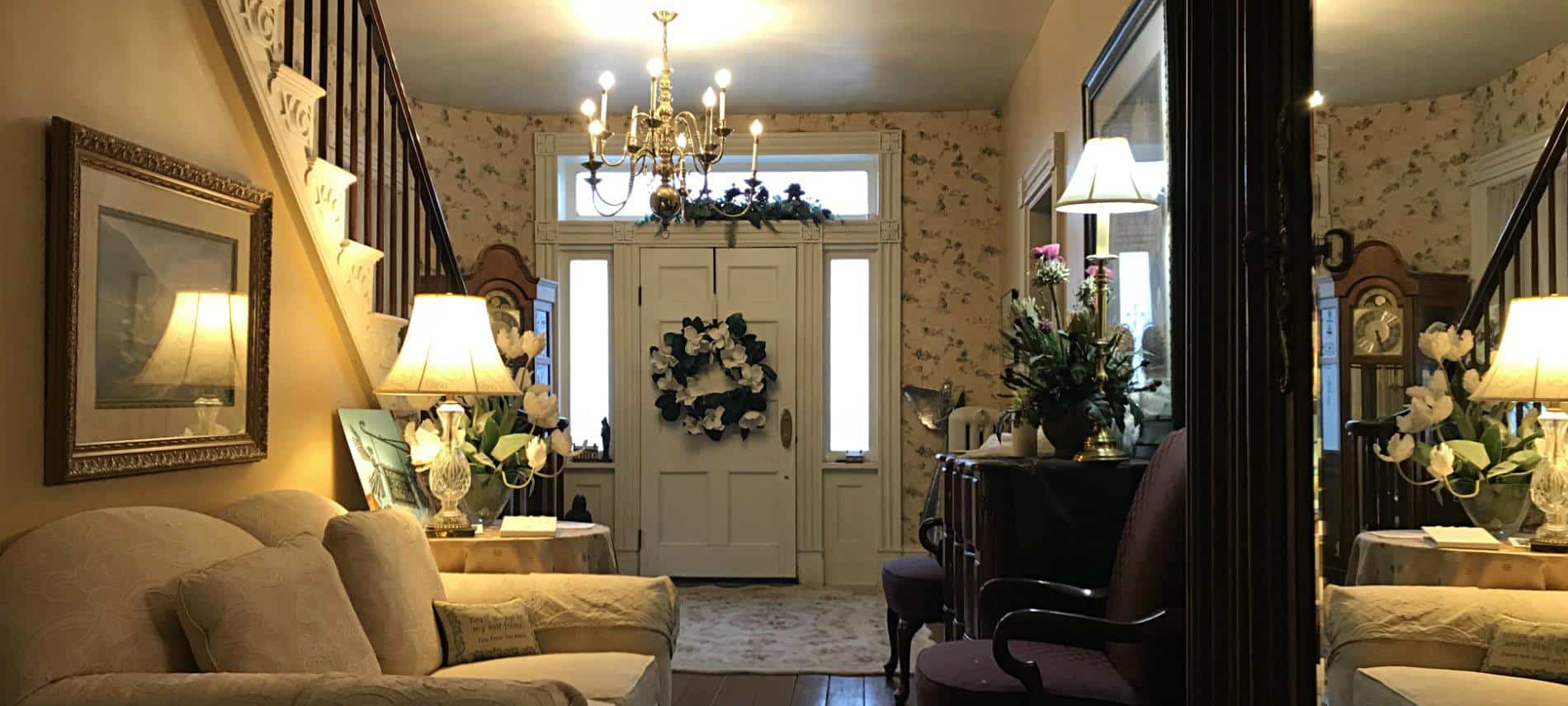 Interior entry with single door with sidelites and transom, staircase to upstairs, wood floors and tables and chairs